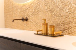 Maatwerk wastafel met gessi kranen en gouden mozaïek