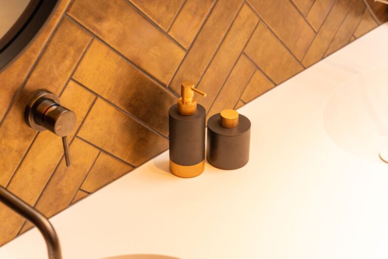 Wastafel met gessi kranen en gouden mozaïek met accessoires
