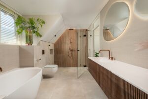 Japandi badkamer met vrijstaand bad, houten wandpanelen en koperen kranen